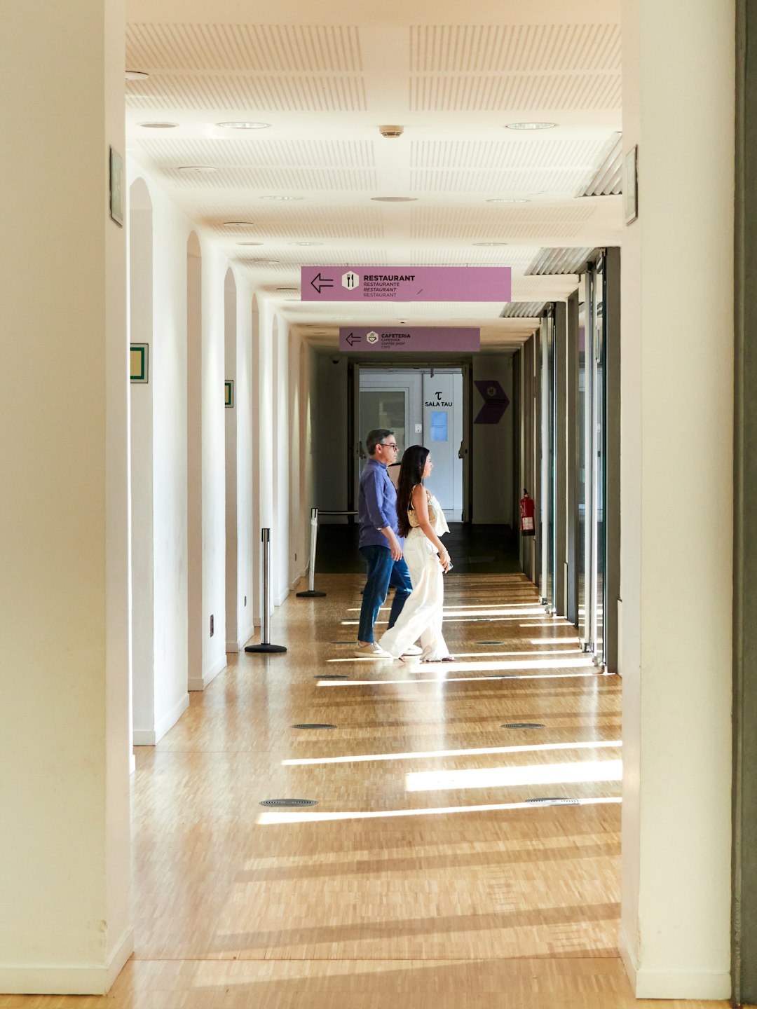 couple-walking-down-a-sunlit-hallway-indoors-ksy4wo107ea